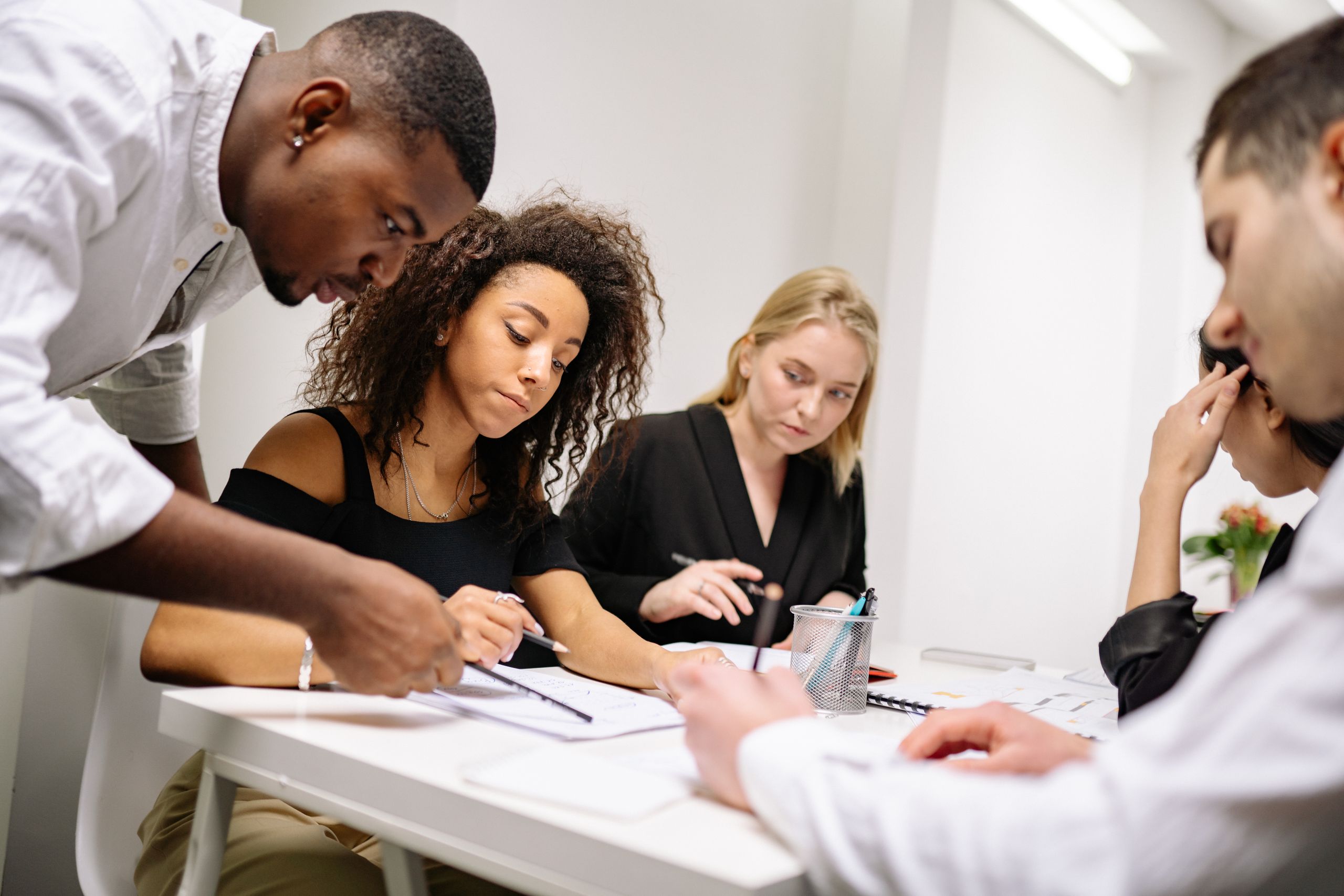A diverse group of professionals working together in a contemporary office setting, fostering teamwork and creativity.